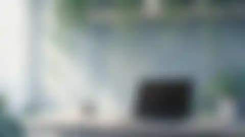 Blurred preview of a desk beneath plants in morning light
